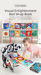 Double-sided black and white high-contrast baby soft book tied to a white crib railing