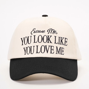 Close-up of black embroidery on contrast canvas baseball cap with slogan detail