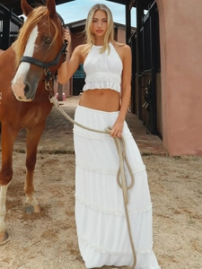 White two-piece summer set with halter ruffle crop top and tiered maxi skirt in barn setting