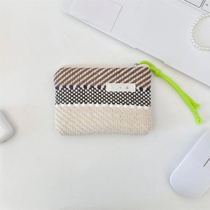 Detail of colorful striped woven mini pouch with a neon green zipper puller