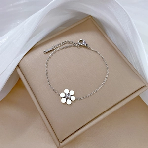 Detailed view of silver six-petal flower chain bracelet on a velvet jewelry box