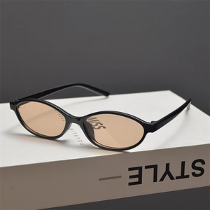 Detailed macro shot of vintage black oval sunglasses featuring stylish amber tinted lenses