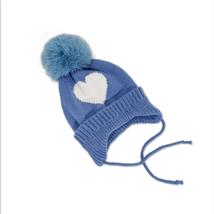 Close-up of navy blue knitted baby hat with white heart pattern and pom-pom detail