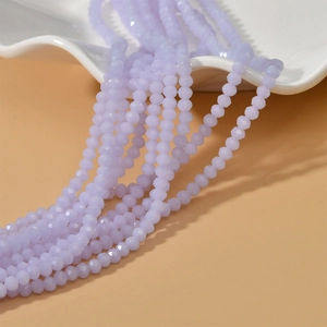 Lavender faceted 4mm wheel beads for DIY jewelry on a wave-shaped white ceramic plate