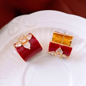 Détail macro de boucles d'oreilles fleur vintage plaquées or 18 carats avec émail rouge