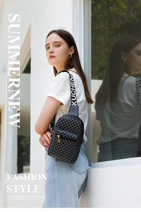 Detail of black sling bag with circular pattern, branded strap, and golden zipper charm