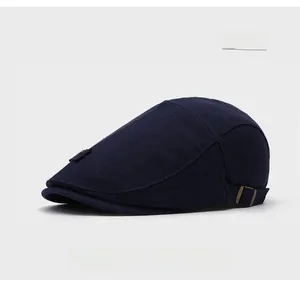 Dettaglio di un cappello da strillone blu con trama a maglia e fibbia in bronzo lucido