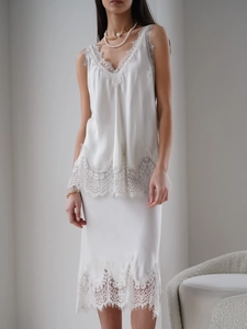 Close-up of white satin camisole with delicate eyelash lace trim and V-neckline detail
