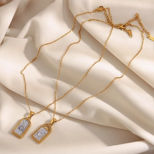 Détail des pendentifs tarot en acier inoxydable plaqué or 18K sur soie beige