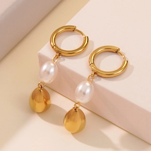 Chic gold-plated teardrop earrings with white pearls on a minimalist pedestal