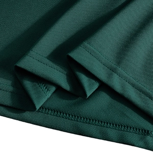 Close-up of dark green pique fabric showing fine stitching and breathable mesh texture