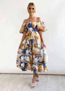 Detail of off-shoulder tiered dress with multi-color abstract print and puff sleeves