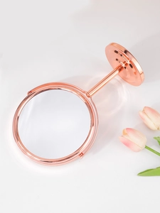 Dettaglio dello specchio da trucco bifacciale oro rosa con base tonda e decorazione a tulipano
