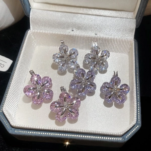 Macro view of six zircon flower pendants with sparkling star-shaped light reflection