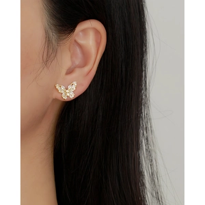 French luxury gold butterfly stud earrings with sparkling crystals shown on ear