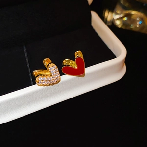 Gros plan de boucles d'oreilles cœur avec émail rouge et zircons sur un écrin à bijoux