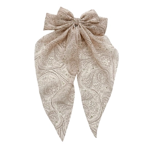 Beige paisley print bow hair clip with long streamers in a bohemian style hair accessory