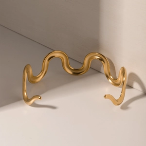 Minimalist 18k gold wave-shaped stainless steel bangle with a matte textured finish