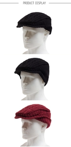 Detail of knitted winter beret with ear protection in black and burgundy colors