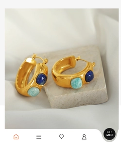 Detail of C-shaped gold-plated hoop earrings with inlaid lapis lazuli and amazonite stones