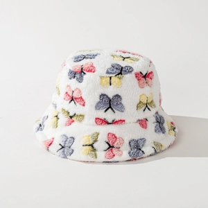 Close-up of white plush bucket hat with colorful butterfly embroidery and soft faux fur texture