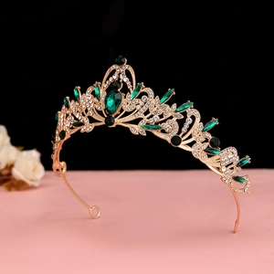 Macro detail of Baroque emerald crown with gold vintage floral patterns and crystals