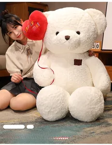 Detail of giant white teddy bear with red heart balloon and soft curly plush texture