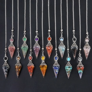 Collection of 14 crystal resin dowsing pendulums with silver chains on black background