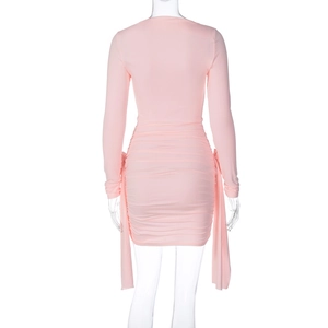 Vue arrière d'une mini-robe rose à manches longues avec des fronces et des rubans