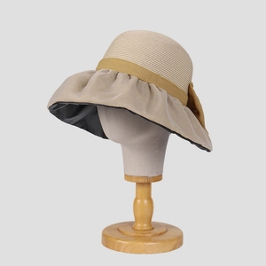 Dettaglio cappello parasole estivo con cupola in paglia, tesa a balze e fiocco laterale