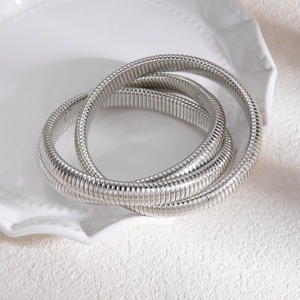 Détail du bracelet extensible multicouche en métal argenté sur plateau en céramique