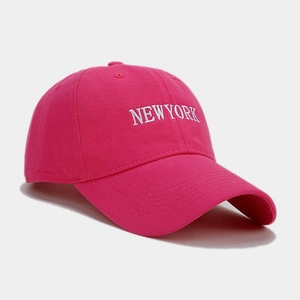 Dettaglio ravvicinato del ricamo bianco NEW YORK su un cappellino da baseball fucsia