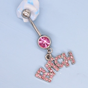 Silver belly button ring with pink crystals and 'Bitch' word pendant on blue background