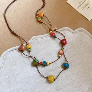 Dettaglio della collana bohémien a doppio strato con perline in ceramica e cordino