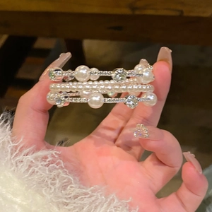 Close-up of elegant multi-layer bracelet with faux pearls and sparkling rhinestones