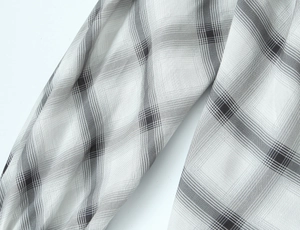 Close-up of black and white plaid woven fabric showing detailed twill texture and fiber