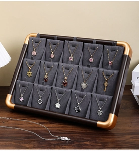 Walnut wood jewelry tray with gray velvet slots and gold corner accents for necklaces