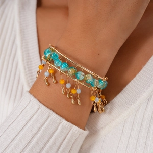 Close-up of bohemian layered beaded bracelet with gold wire and colorful charms
