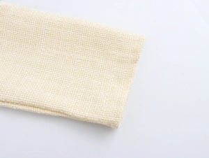Macro shot of beige tweed fabric texture on a French style elegant dress hemline