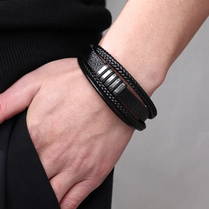 Men's multilayer braided leather bracelet with silver magnetic buckle on a model's wrist