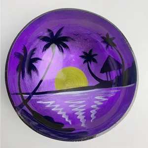 Detail of handcrafted coconut bowl featuring tropical sunset painting and natural shell texture