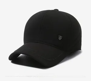 Dettaglio cappello invernale nero in tessuto strutturato con scudo metallico logo M