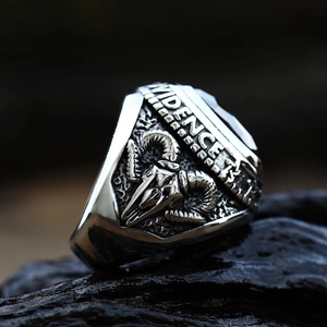 Close-up of retro silver sheep skull ring with detailed side engraving on dark stone