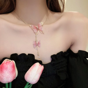 Elegant gold necklace with pink tulle butterflies and tassels on female model
