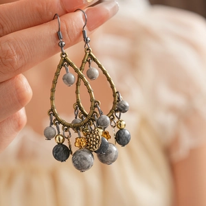 Macro shot of vintage teardrop earrings with marble textured beads and bronze frames