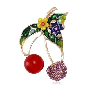 Cute cherry brooch with red beads and pink rhinestones on a white background