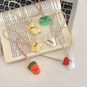Cute plush cartoon animal hair ties including frog, moon and star displayed on an open book