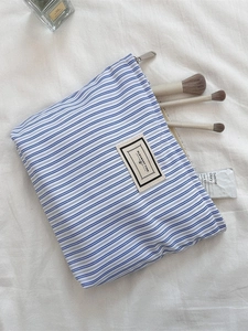 Blue striped canvas makeup bag with zipper and Pleasant Time label for travel storage