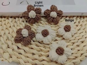 Close-up of handmade crochet milk cotton flowers in beige and coffee brown colors
