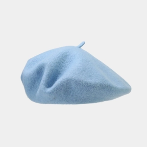 Detailed texture of light blue wool beret hat showing felt material and top stem